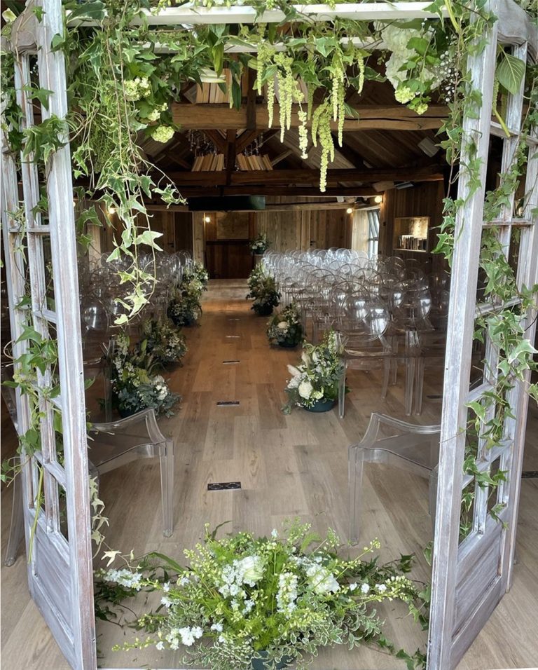 Belle salle de mariage avec une arche fleurie, chaque rang est fleuri