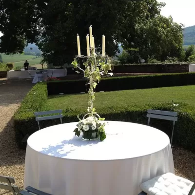 Composition florale élégante avec bougies sur une table, événement en extérieur